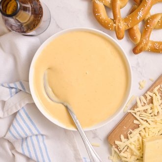 Beer cheddar cheese dip with a spoon in it.