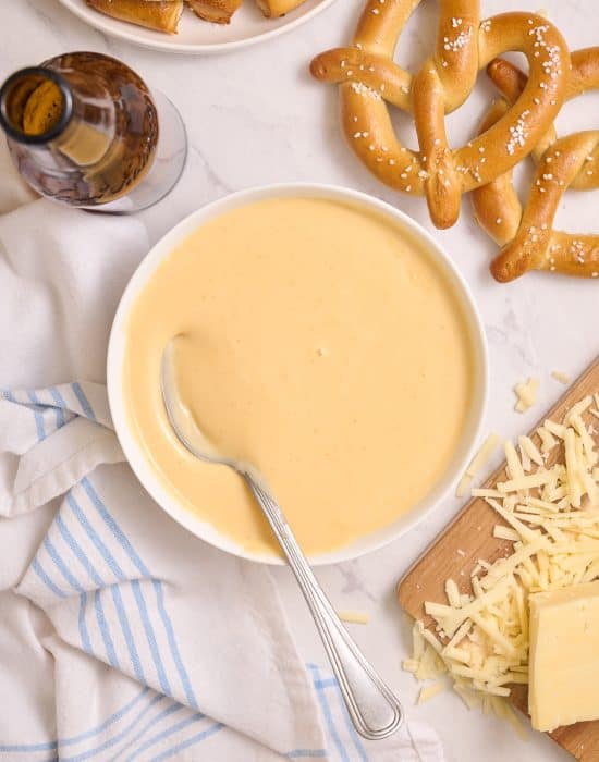Beer cheddar cheese dip with a spoon in it.