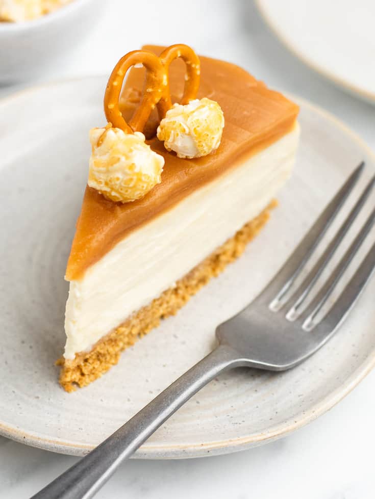 A slice of no bake caramel cheesecake on a white plate. 