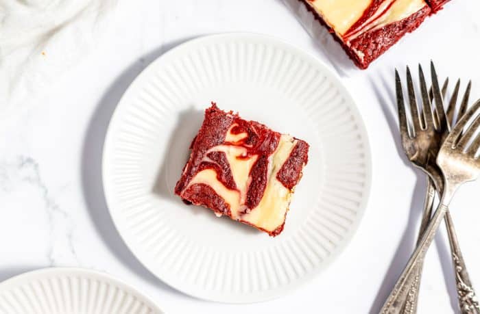 A plate with a red velvet cheesecake brownie.