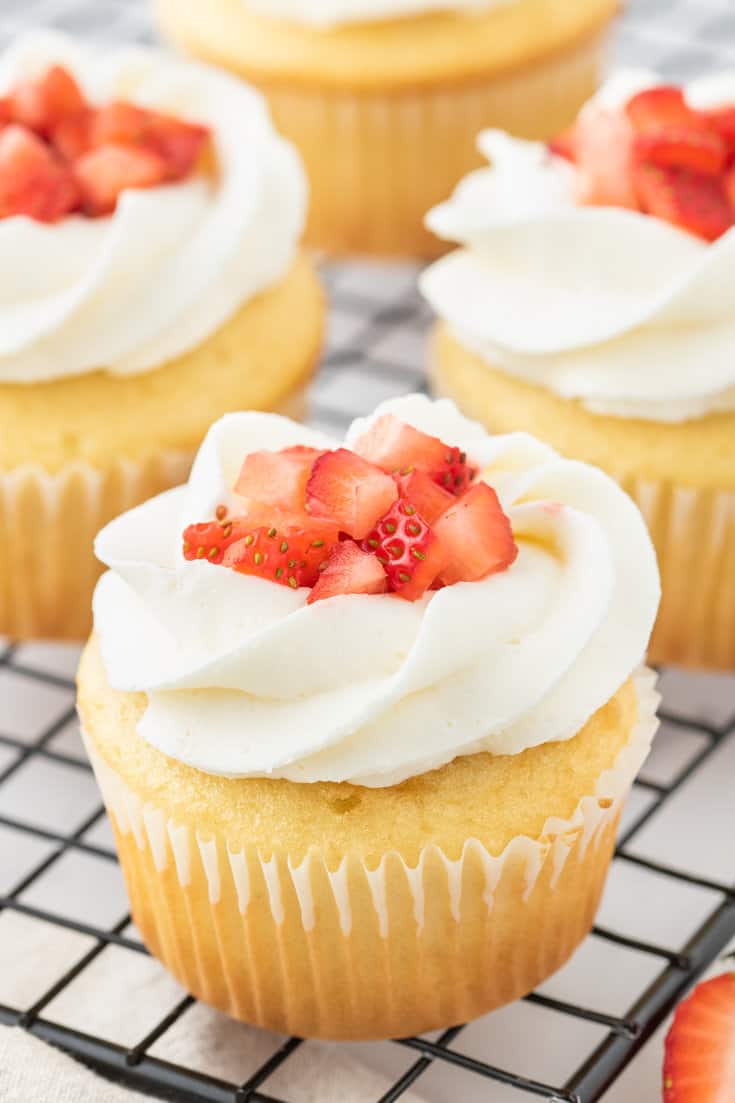 Strawberry shortcake cupcakes on a cooling rack. 