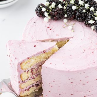 Blackberry layer cake with a slice removed.