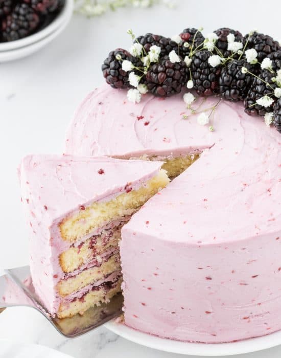 Blackberry layer cake with a slice removed.