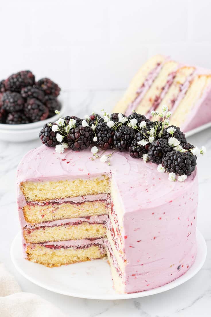 Blackberry layer cake with slices removed.