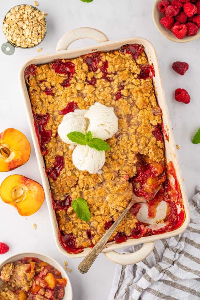 Peach raspberry crumble with a spoon in it. 