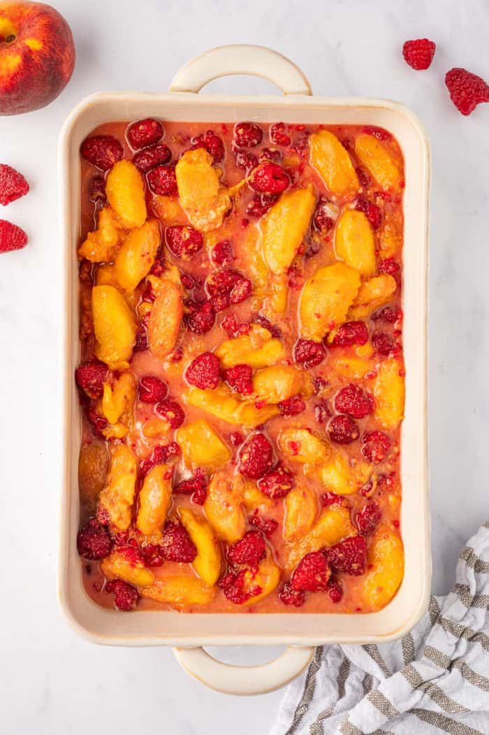 Peach raspberry crumble with filling in a baking dish.