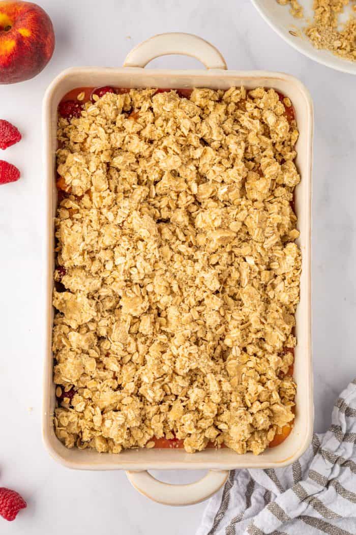 Peach raspberry crumble with the topping spread on it and unbaked.