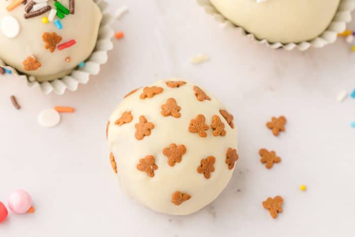 A closeup of a gingerbread truffe with gingerbread man sprinkles.