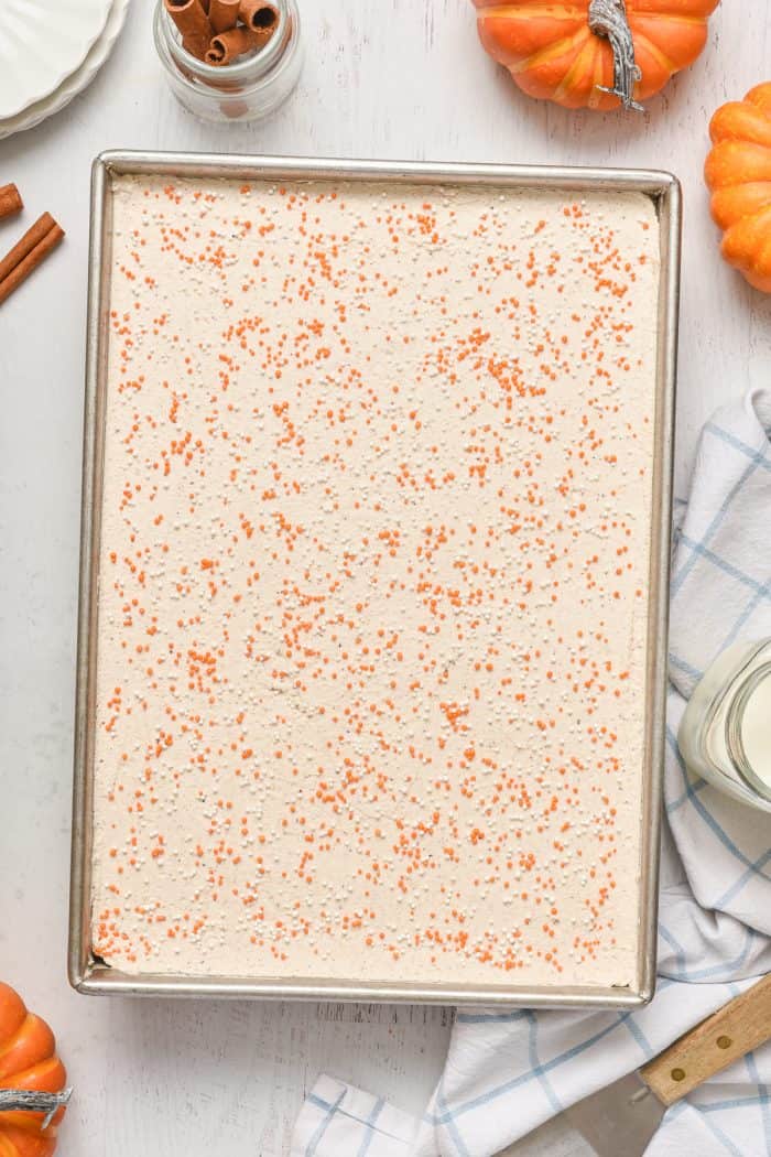 Frosted cake with orange and white sprinkles.