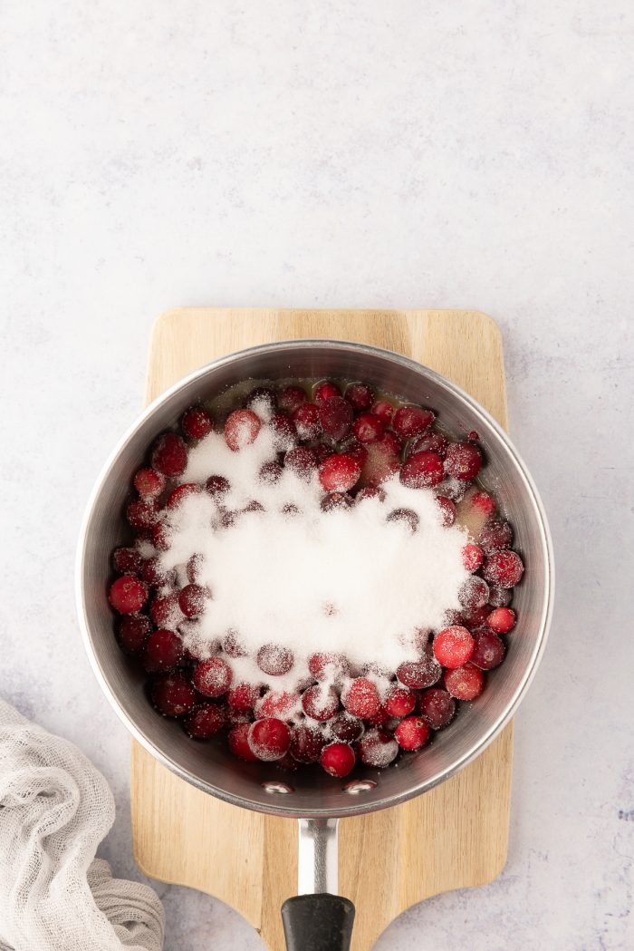 Cranberries, sugar, and orange juice in a saucepan.