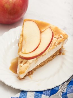 A closeup of a no bake caramel apple cheesecake on a white plate.