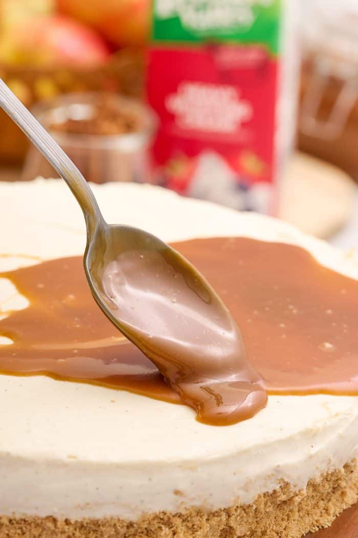 Caramel sauce being spooned over the no bake cheesecake.