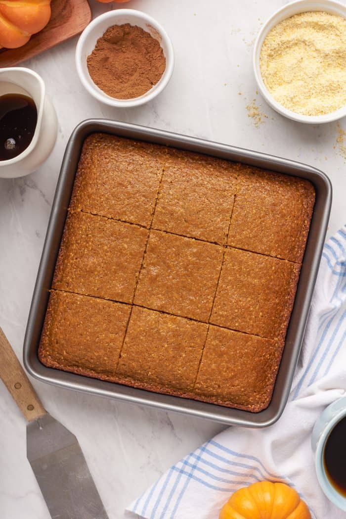A baking tray with baked pumpkin cornbread that has been sliced.