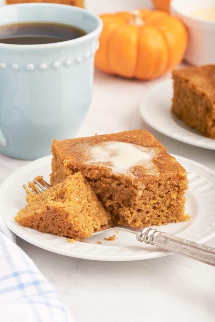A slice of pumpkin cornbread with a fork slicing through it.
