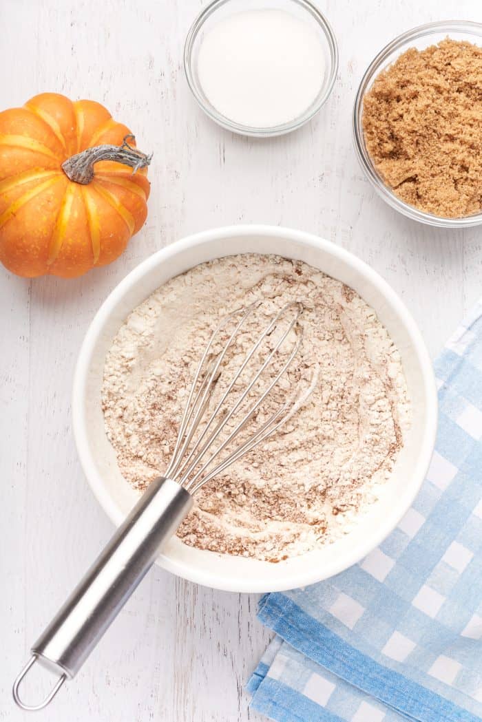 A white bowl with flour and pumpkin spice.