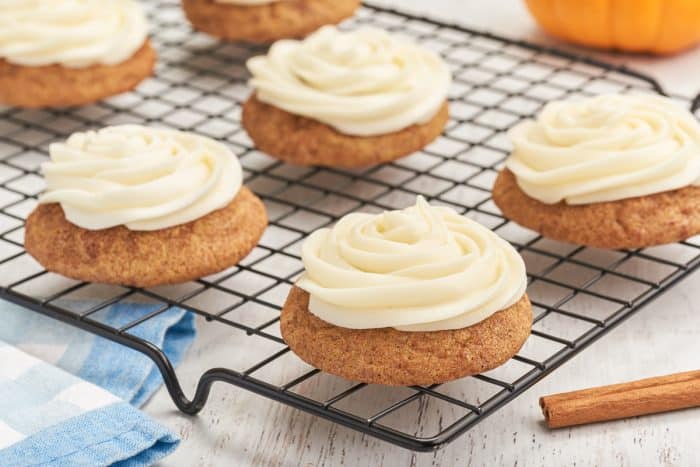 A cooling rack with frosted pumpkin snickerdoodles.