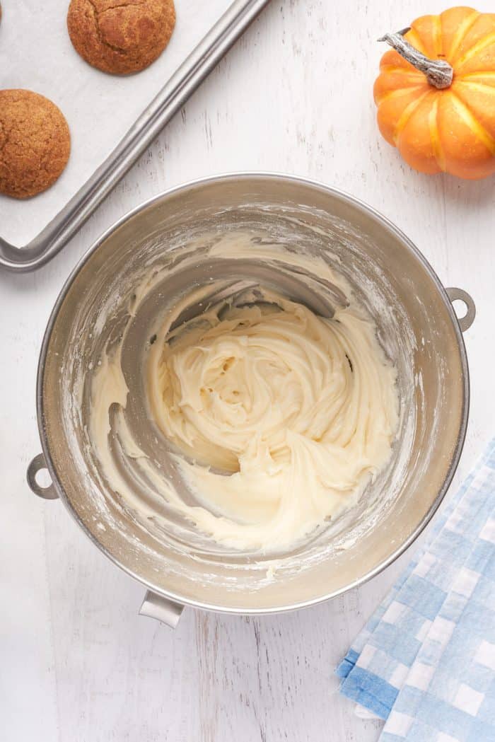 A mixing bowl with cream cheese icing.