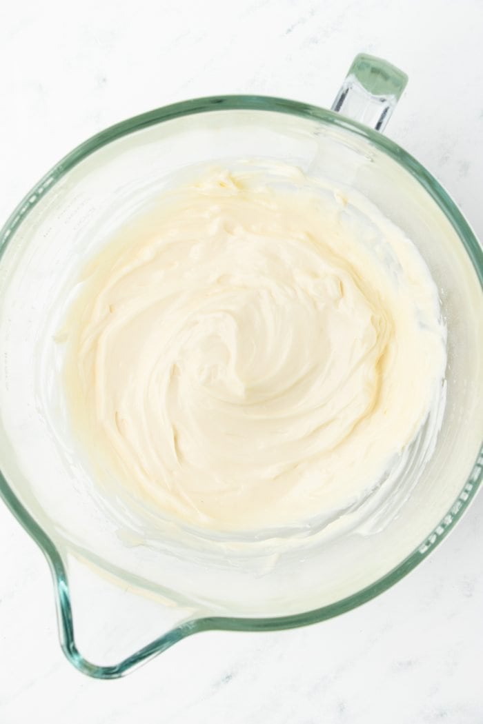 Cream cheese in a glass mixing bowl.