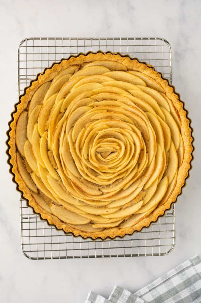 The baked apple tart on a cooling rack.