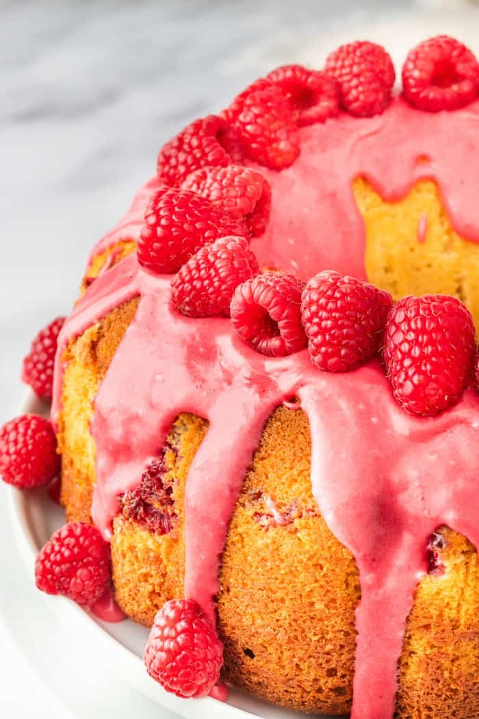 A bundt cake decorated with fresh raspberries.