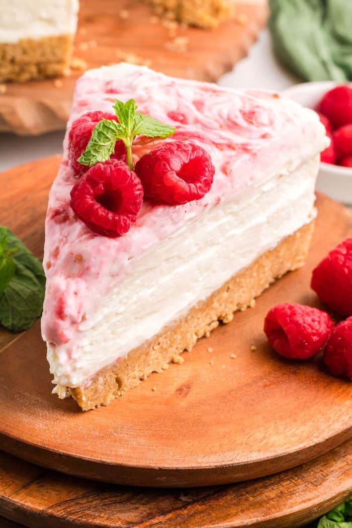 An up close image of a slice of no bake raspberry lemon cheesecake.