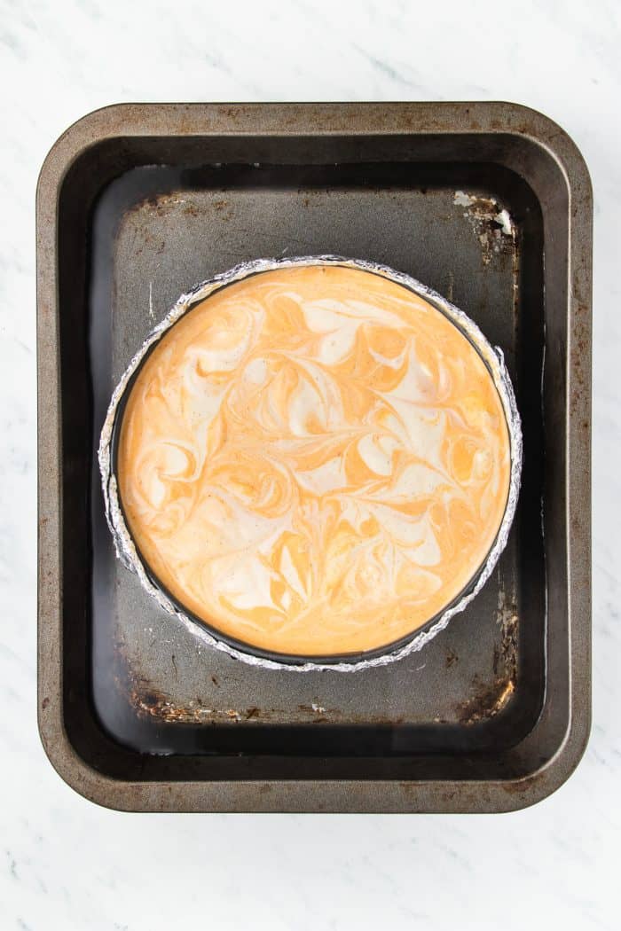 The unbaked cheesecake in a baking pan.