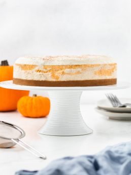 An image of the whole pumpkin swirl cheesecake on a cake stand.