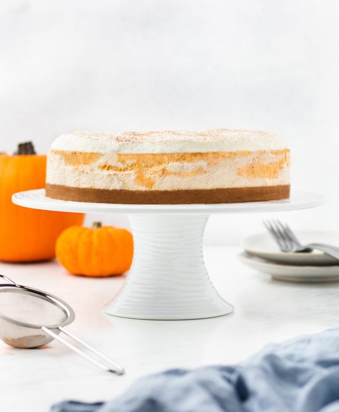 An image of the whole pumpkin swirl cheesecake on a cake stand. 