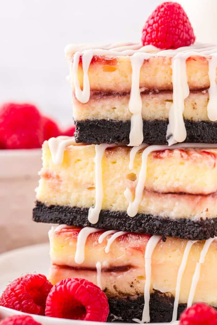A stack of 3 white chocolate raspberry cheesecake bars.