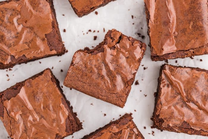 An overview image of the tops of brownies on a white background.