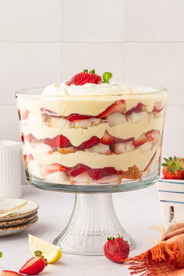 A strawberry trifle in a trifle bowl showing all of the layers.