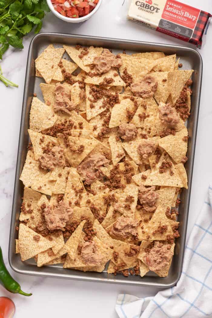 Tortilla chips with a layer of ground beef and refried beans.