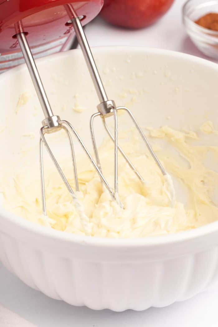 A white bowl of mascarpone being whipped.