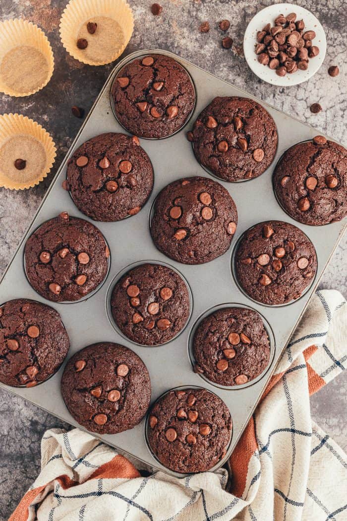 A muffin pan filled with double chocolate muffins that have been baked. 