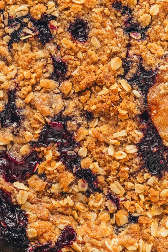 A closeup of blueberry peach crumble showing the topping and parts of the filling.