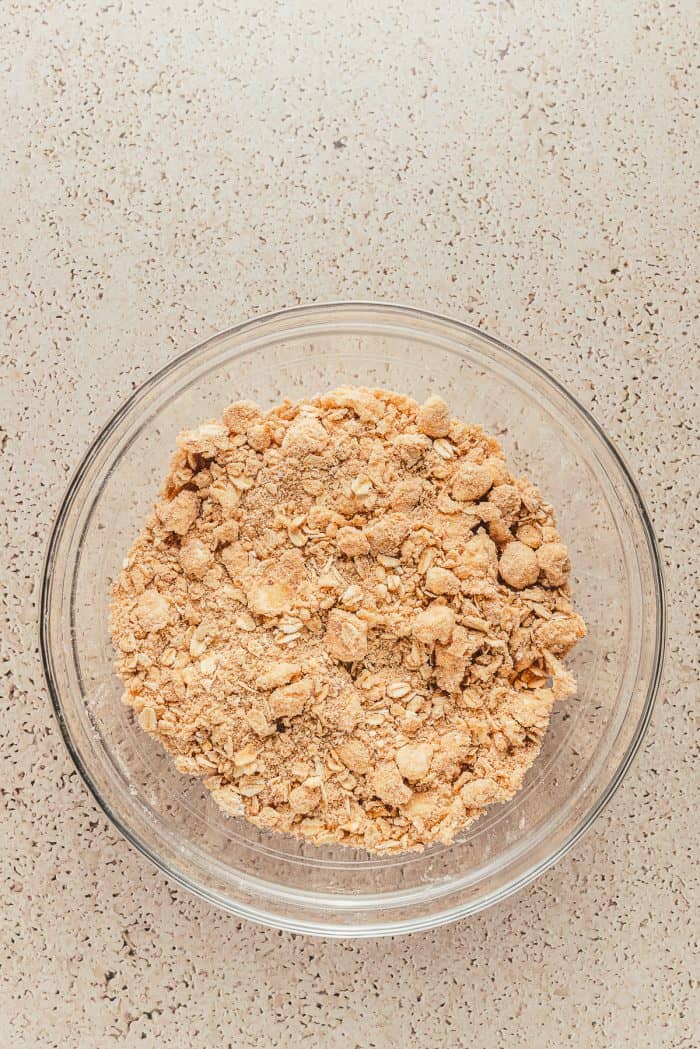 A glass bowl with crumble topping.