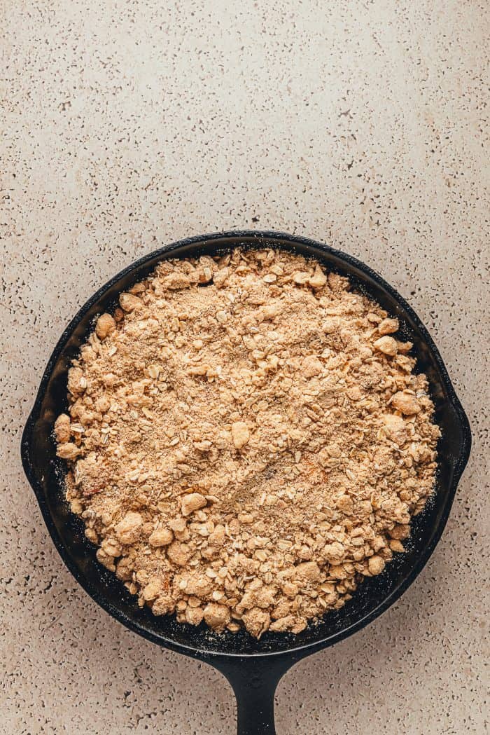 A cast-iron skillet with an baked crumble in it.