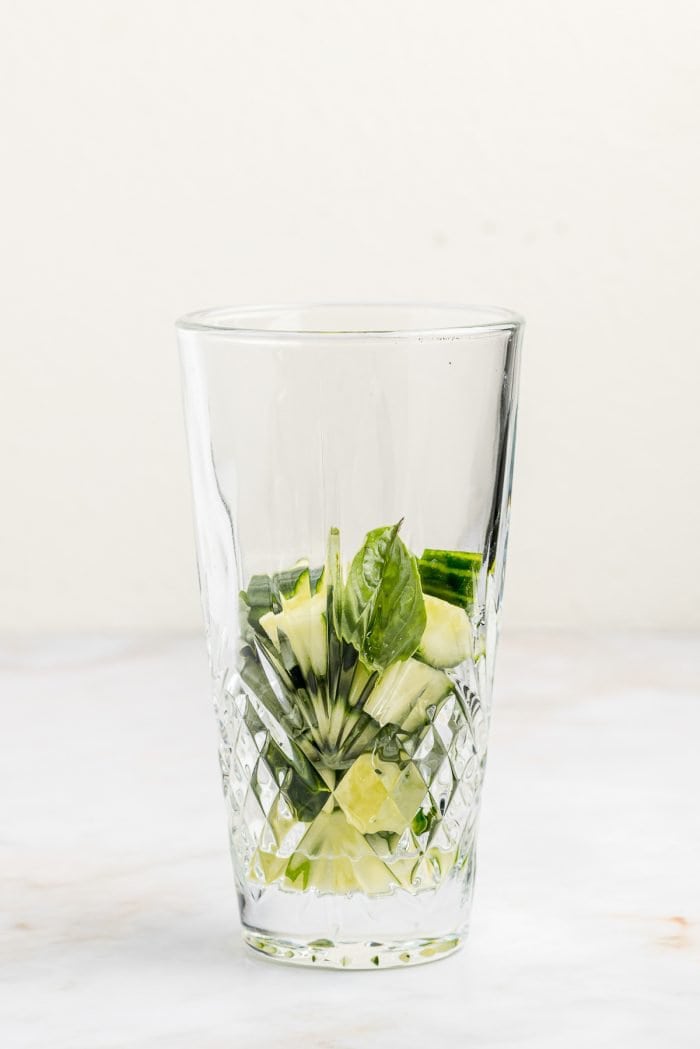 A glass with cucumbers in it.