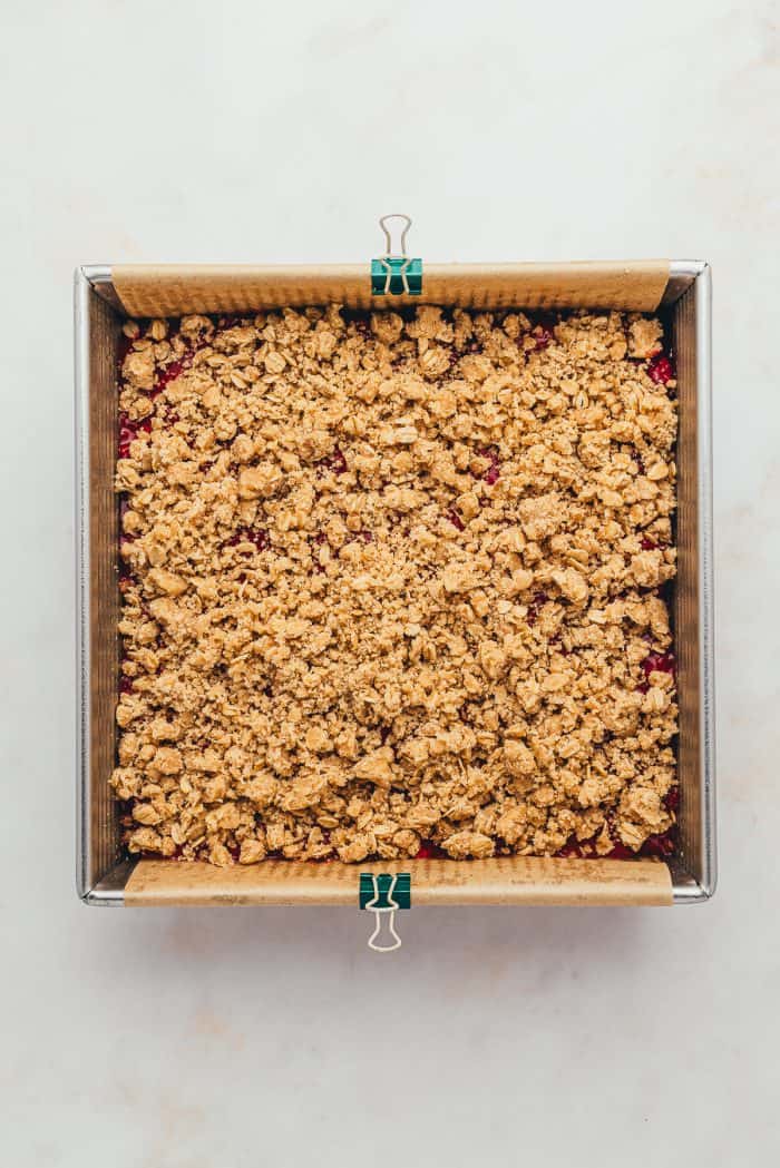 A baking tray with unbaked raspberry crumble bars.