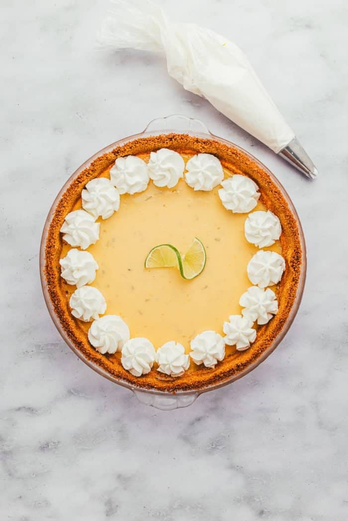 A key lime pie garnished with whipped cream. 