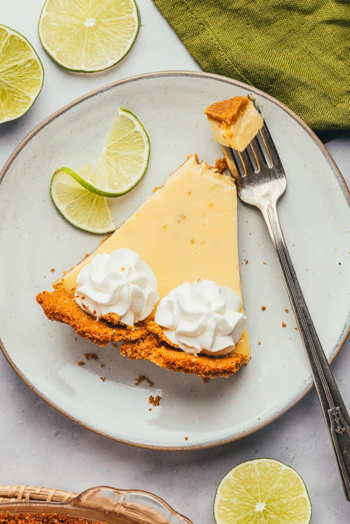 A plate with a slice of key lime pie and a fork. 