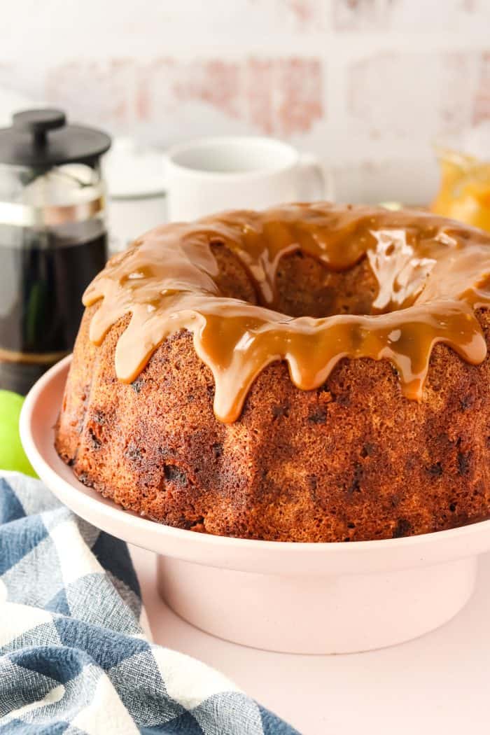 An image showing the whole caramel apple Bundt cake on a white cake stand.