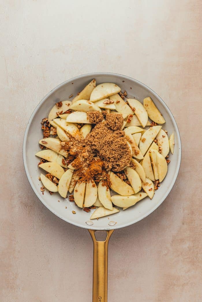 Sliced green apples in a skillet with brown sugar.