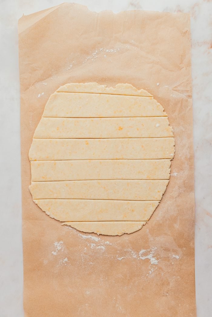 Rolled out pie dough that has been cut into strips.