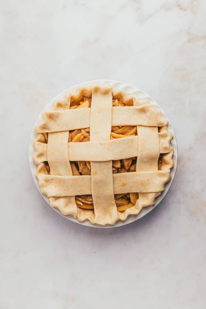 An unbaked apple pie with a lattice crust. 