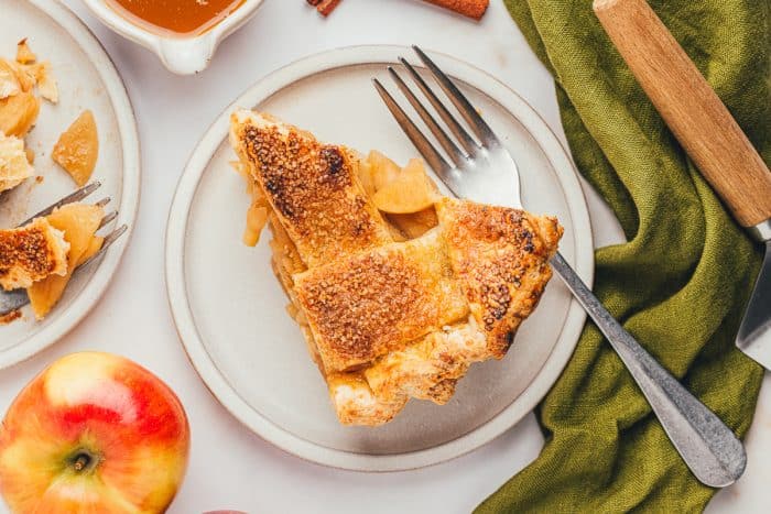 A slice of apple pie on a white plate.