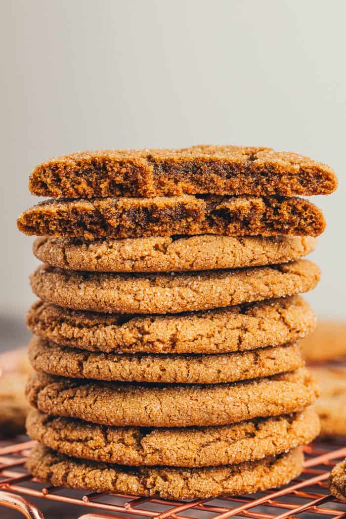 A pile of ginger molasses cookies with a cookie broken in half.