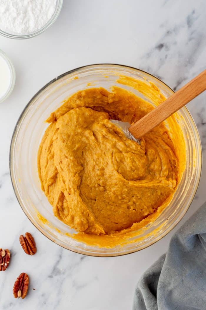 Mixing the pumpkin cake batter in a glass bowl.