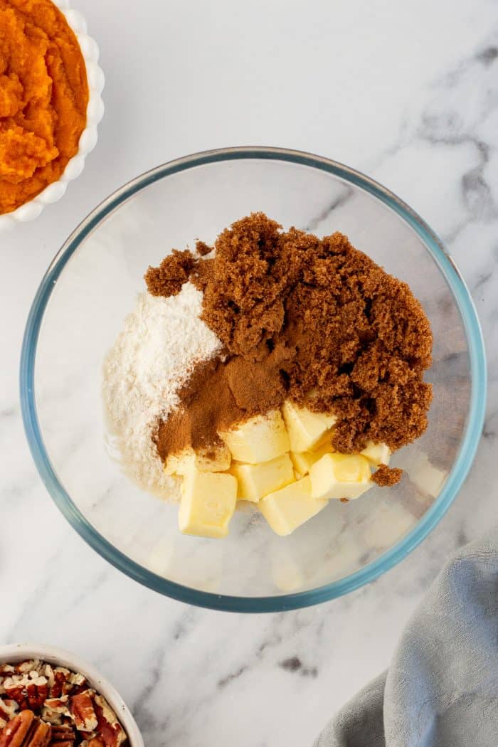 A glass bowl filled with butter, brown sugar, flour, and cinnamon. 