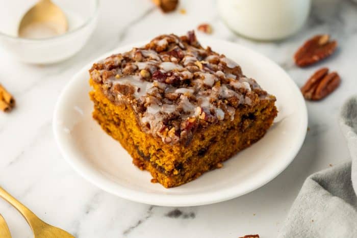 A white plate with a slice of pumpkin coffee cake.